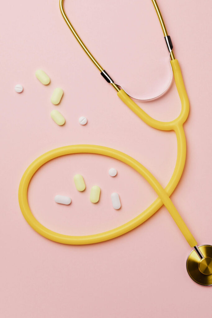 stéthoscope et médicaments sur un fond rose