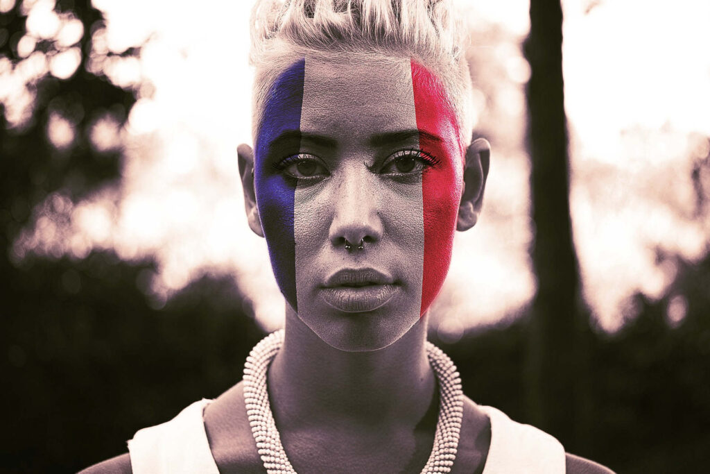 Visage de femme en gros plan, le visage peint aux couleurs du drapeau français.
