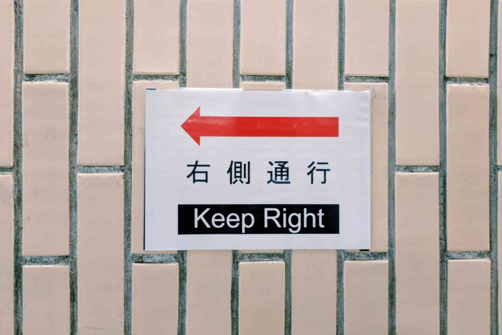 Une feuille collée sur un mur indique en anglais de "rester à droite", avec une flèche indiquant la gauche.
