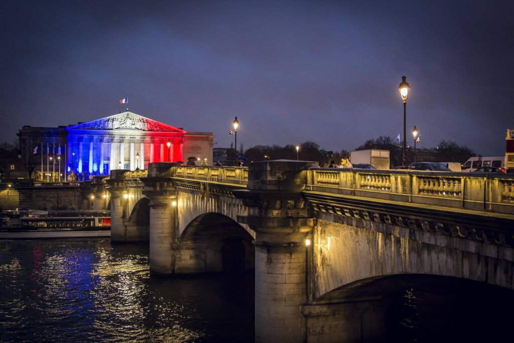Le Palais-Bourbon, siège de l'Assemblée nationale, illuminé aux couleurs du drapeau français.