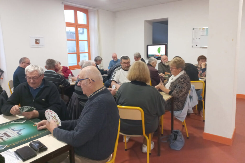 Une vingtaine d’adhérents répartis par groupe de quatre joueurs sont attablés, cartes de tarot à la main, et enchaînent les parties.