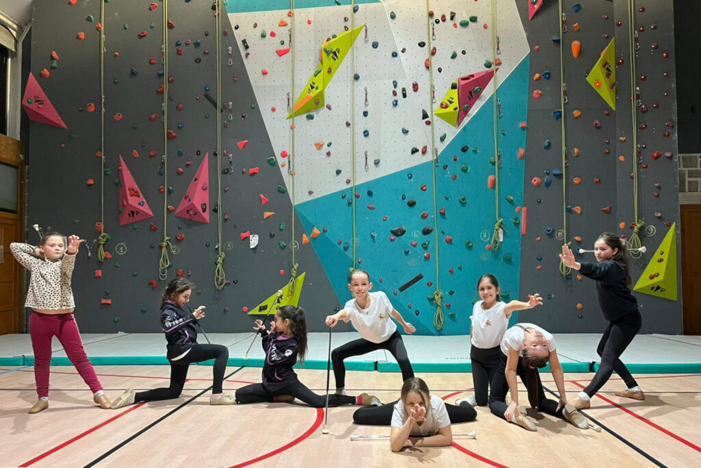 jeunes filles pratiquant le twirling majorette en position finale de leur chorégraphie dans un gymnase au Mayet de Montagne.