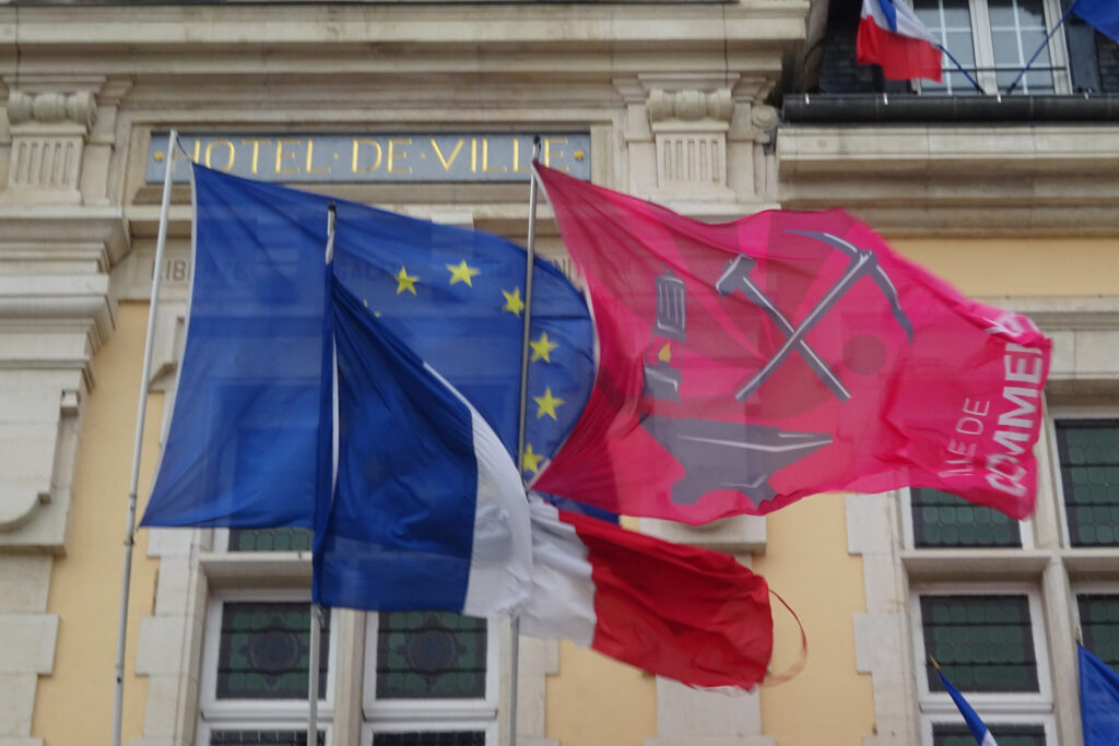 Les drapeaux français et européen flottent aux côtés de celui de la ville de Commentry, aux couleurs du mouvement ouvrier.