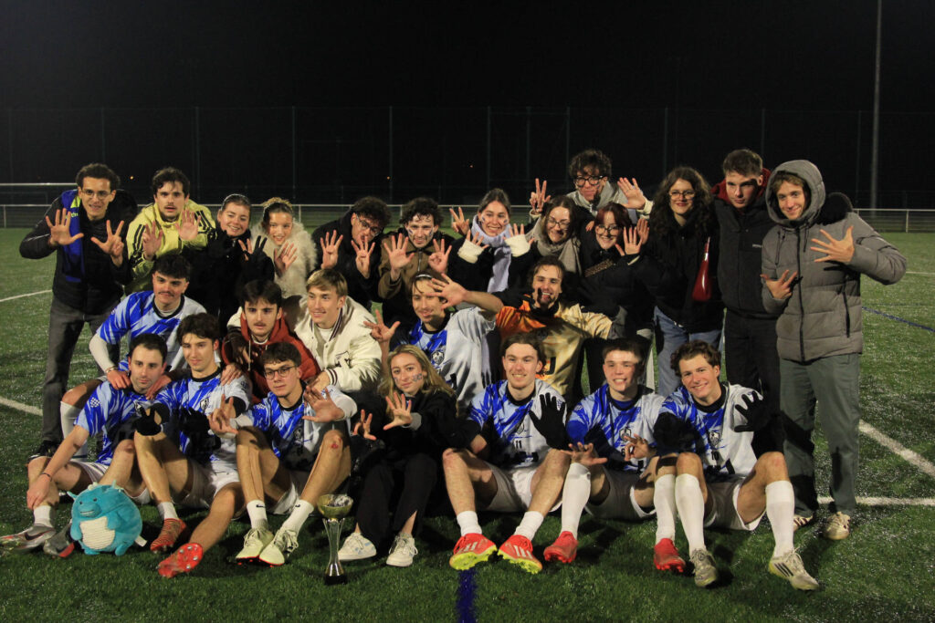 L'équipe ICJ avec son trophée au centre du terrain.