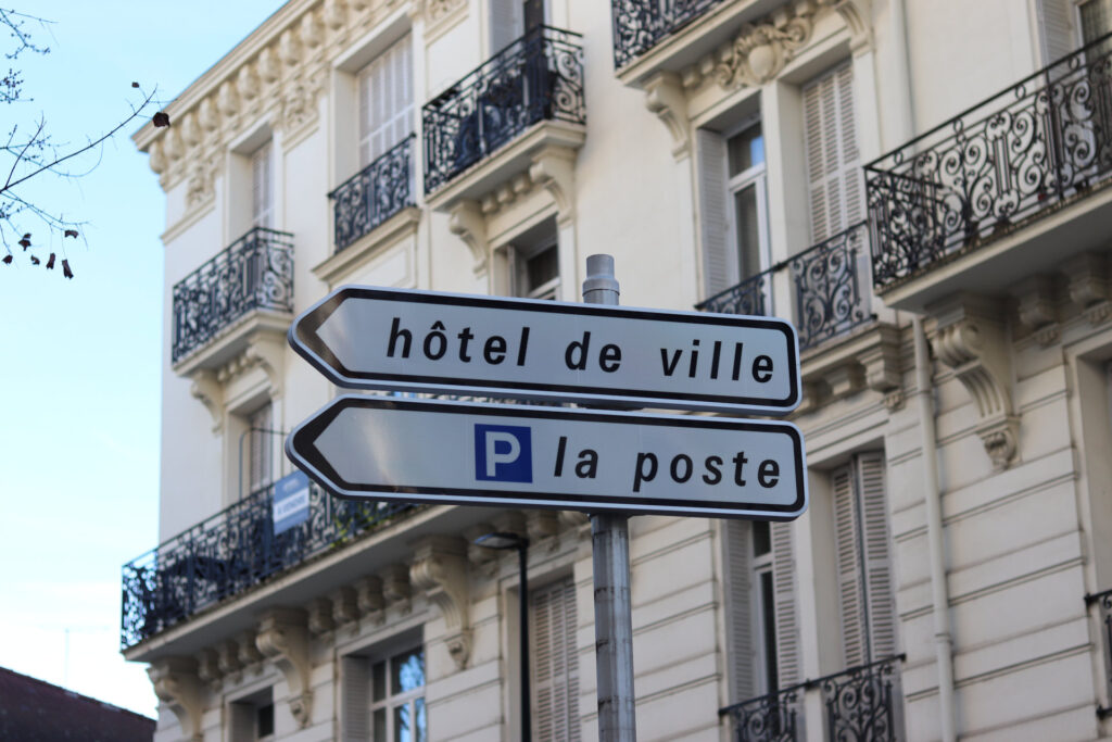 Ce panneau indique la direction vers l’Hôtel de ville (à gauche) et la place de la Poste (à droite).
