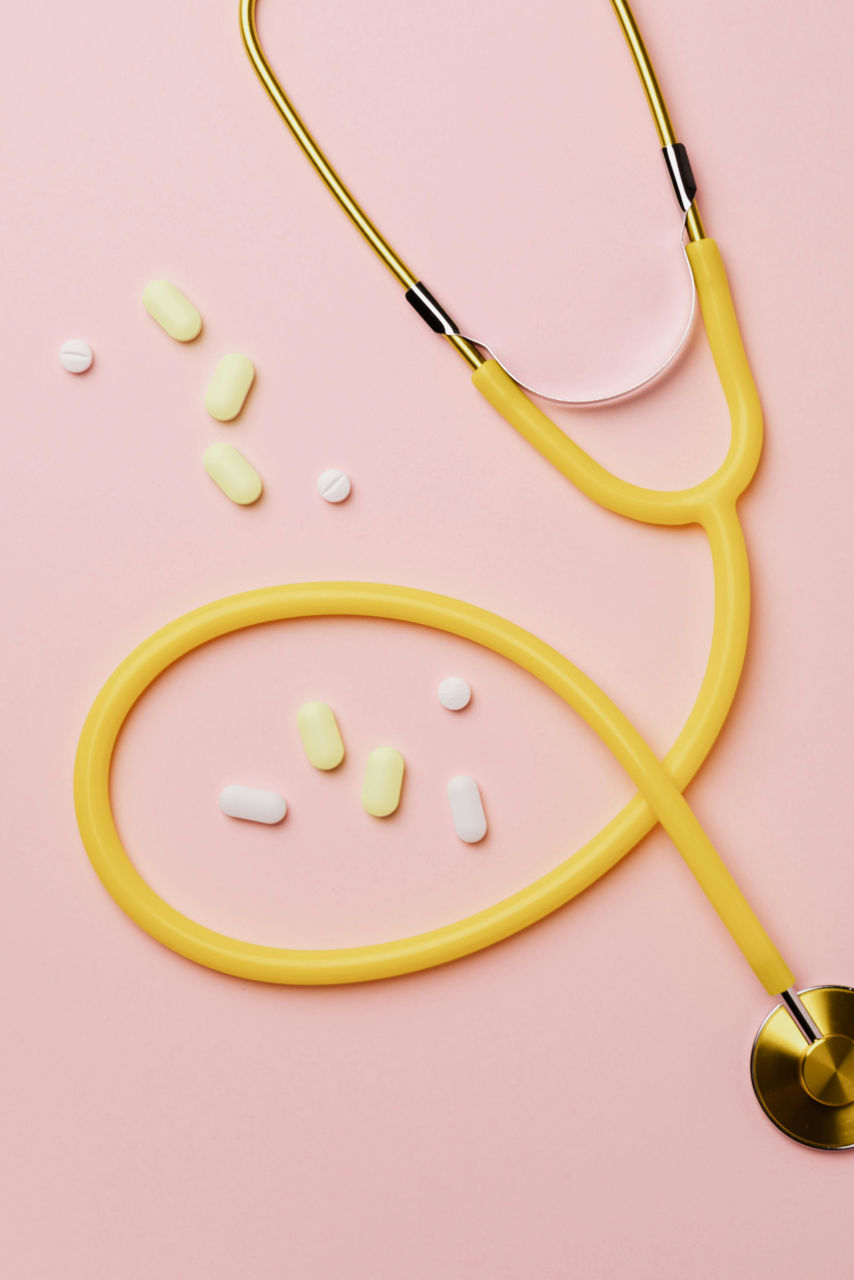 stéthoscope et médicaments sur un fond rose