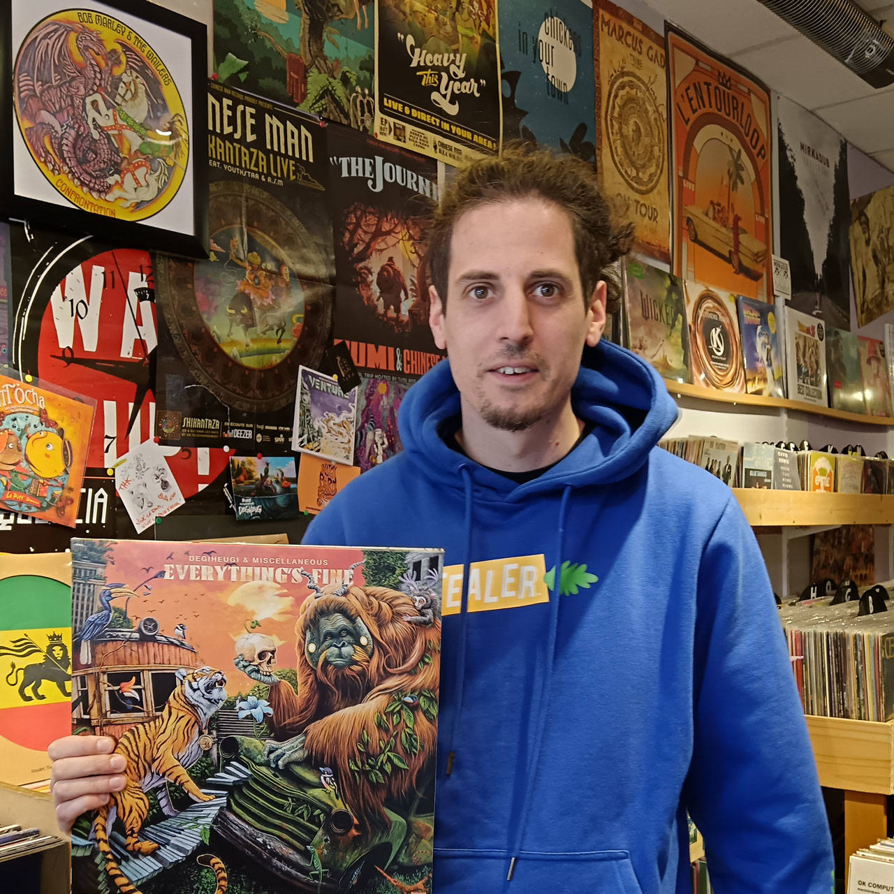 Portrait du disquaire tenant une pochette de disque vinyle.