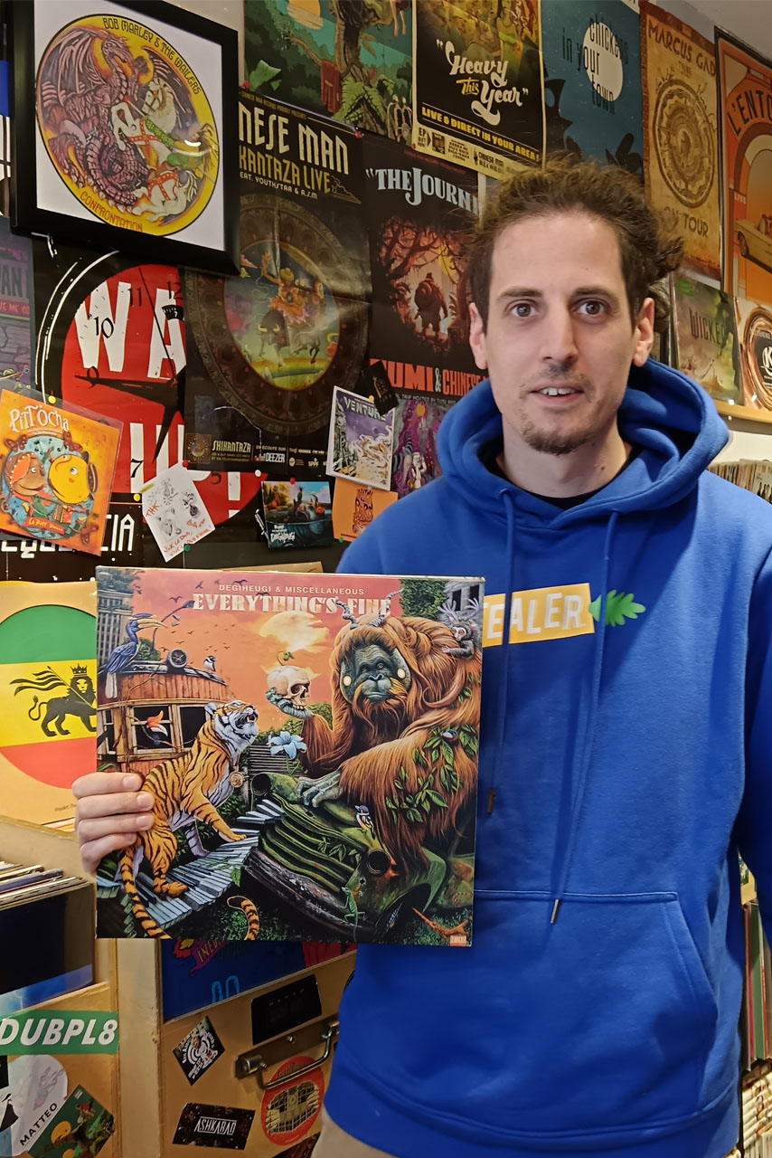 Portrait du disquaire tenant une pochette de disque vinyle.