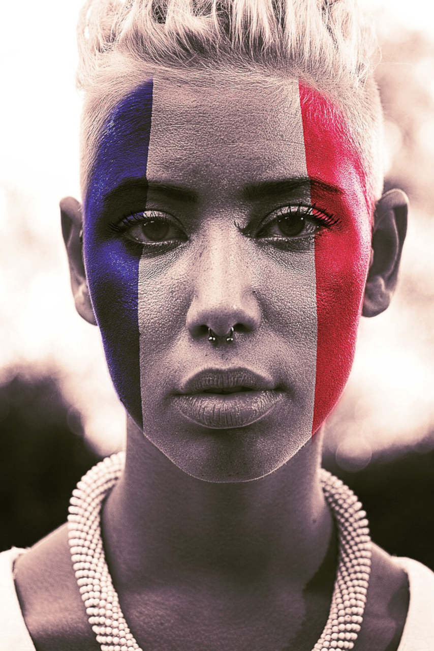 Visage de femme en gros plan, le visage peint aux couleurs du drapeau français.
