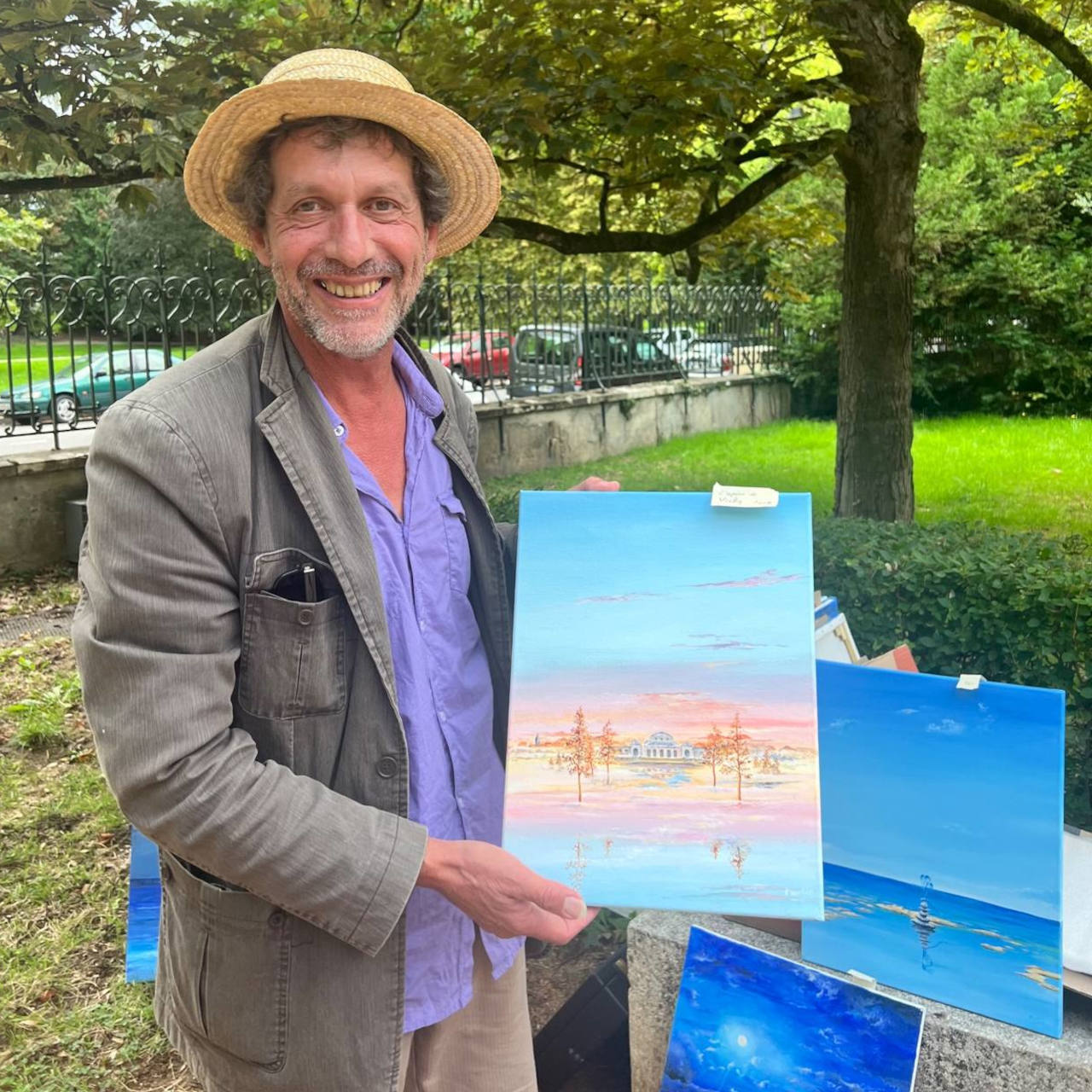 Franck Martin tient dans ses mains le tableau qu’il a réalisé représentant l’Opéra de Vichy dans un monde imaginaire. Il se trouve toujours dans un cadre verdoyant.