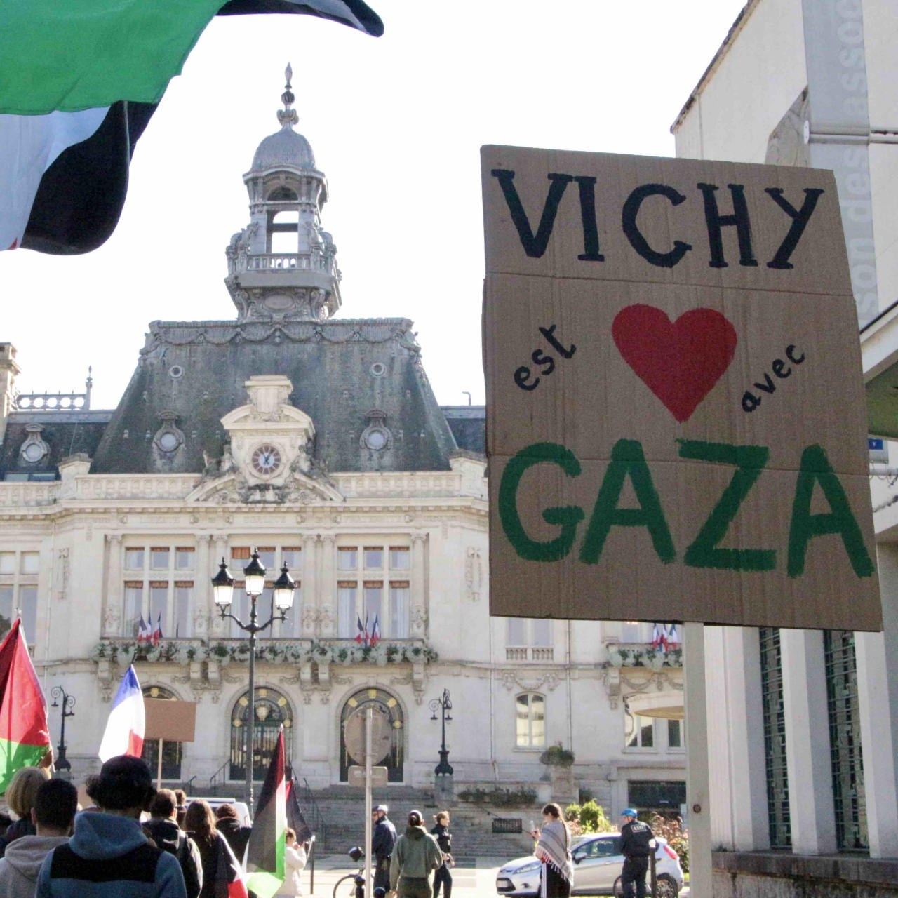Des drapeaux palestiniens et des pancartes de soutien à la Palestine flottent au-dessus du cortège de manifestants qui se dirige vers la mairie.