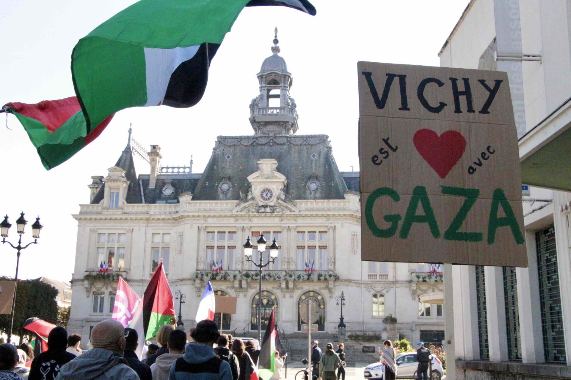 Des drapeaux palestiniens et des pancartes de soutien à la Palestine flottent au-dessus du cortège de manifestants qui se dirige vers la mairie.