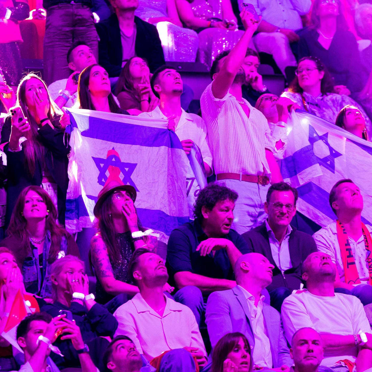 Des supporters israéliens brandissant le drapeau de leur délégation scrutent les résultats de l'édition 2025 de l'Eurovision.