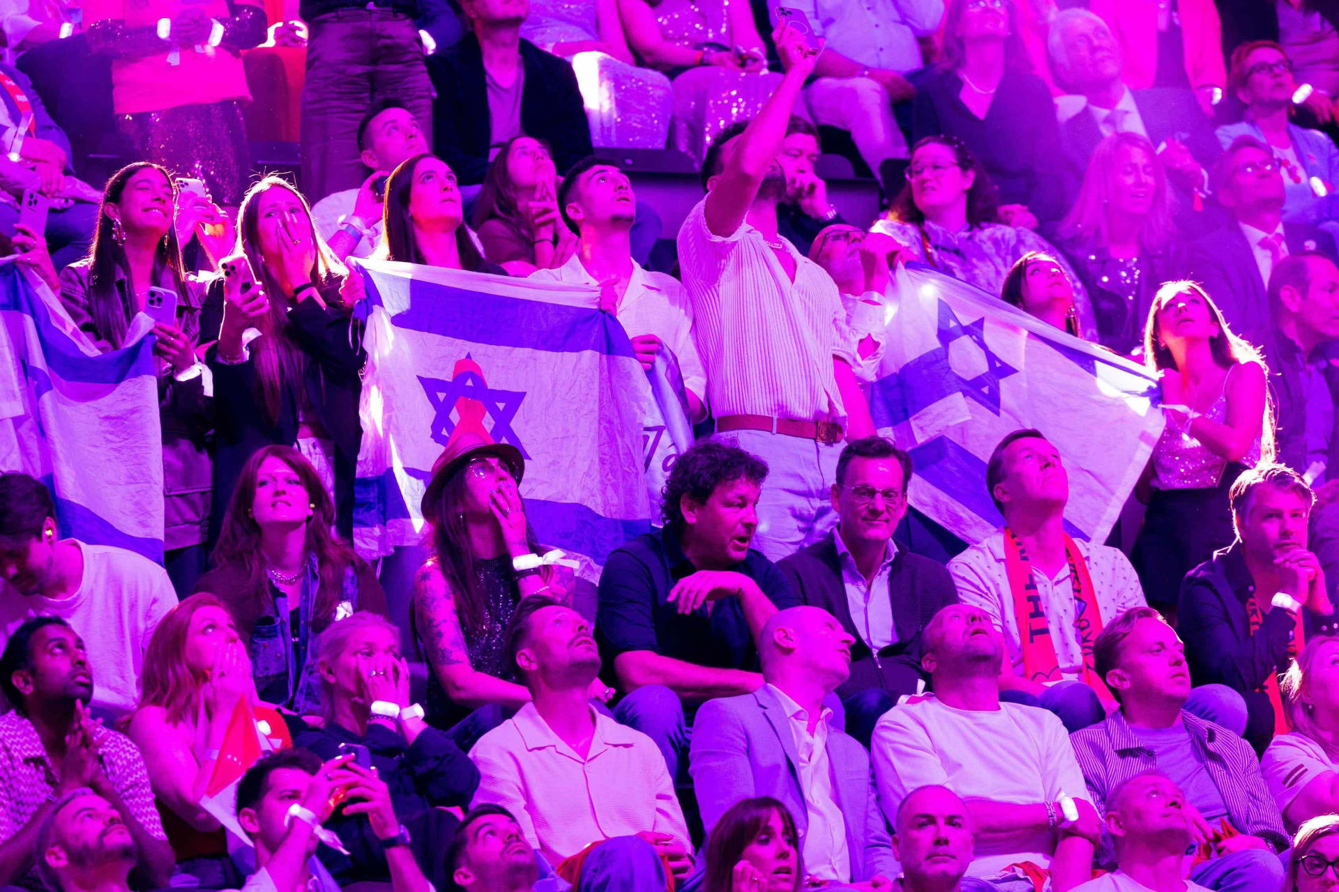 Des supporters israéliens brandissant le drapeau de leur délégation scrutent les résultats de l'édition 2025 de l'Eurovision.