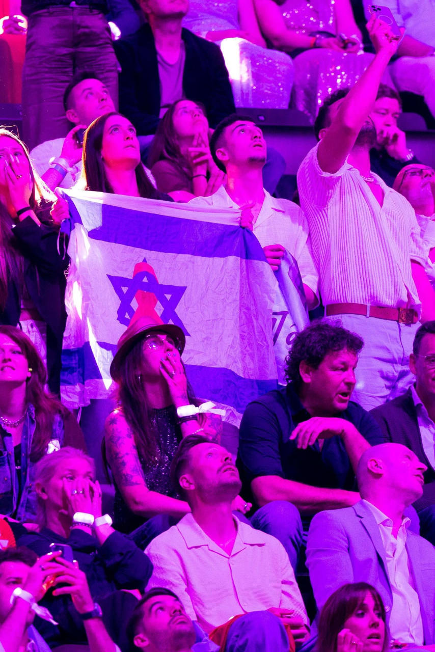 Des supporters israéliens brandissant le drapeau de leur délégation scrutent les résultats de l'édition 2025 de l'Eurovision.