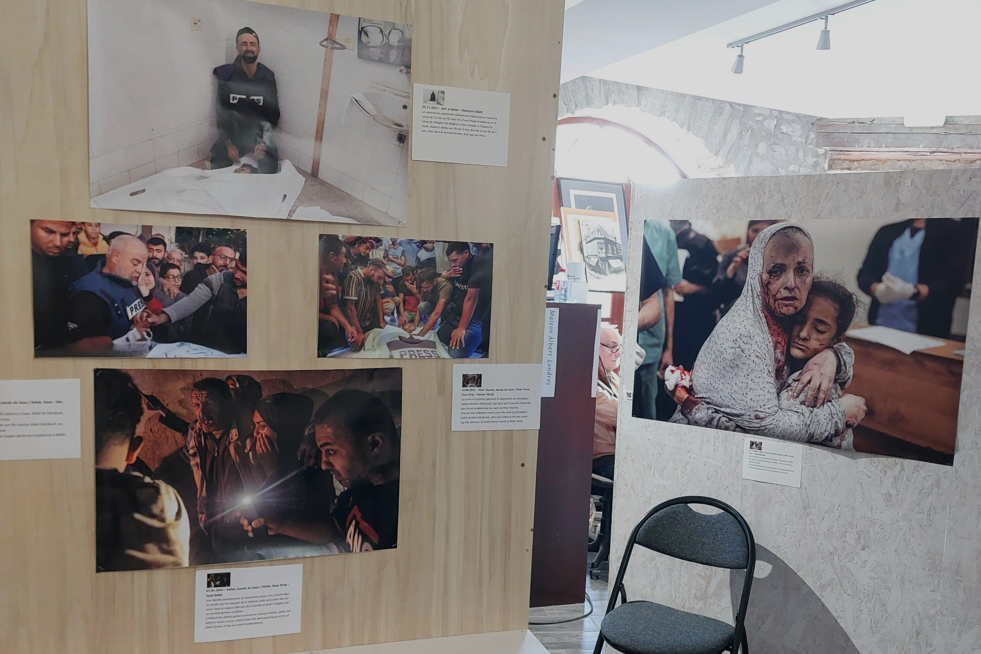 Plusieurs photos exposées, dont quatre sur la gauche qui immortalisent la souffrance des journalistes et de leur proche à Gaza, et une autre photo sur la droite qui présente une femme et une jeune fille blessées qui s'enlacent.