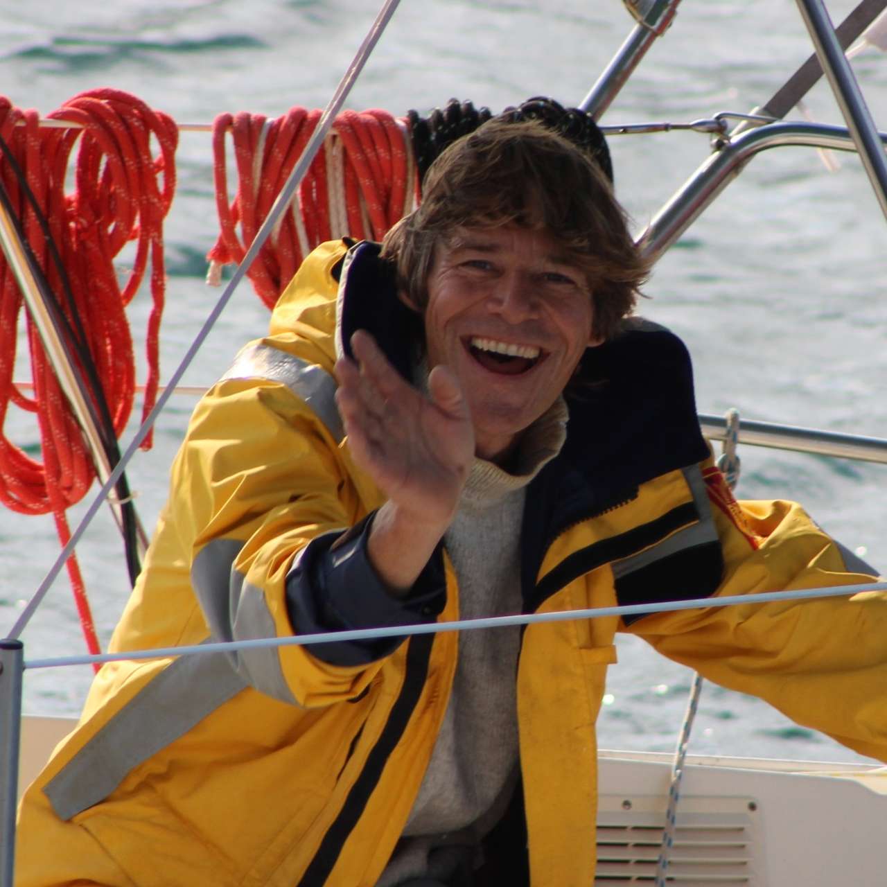 Un marin sourit à l'appareil depuis son bateau.