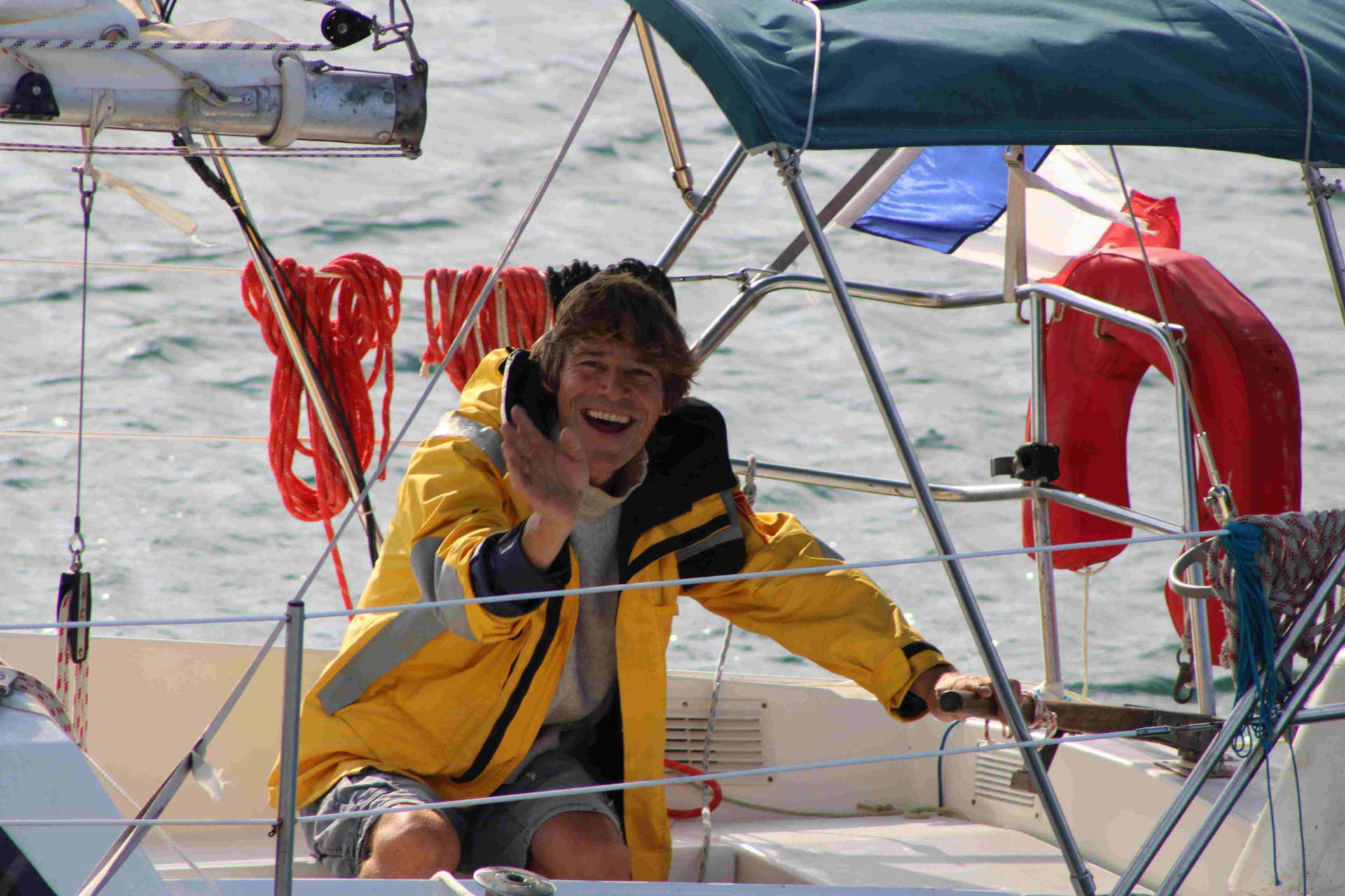 Un marin sourit à l'appareil depuis son bateau.
