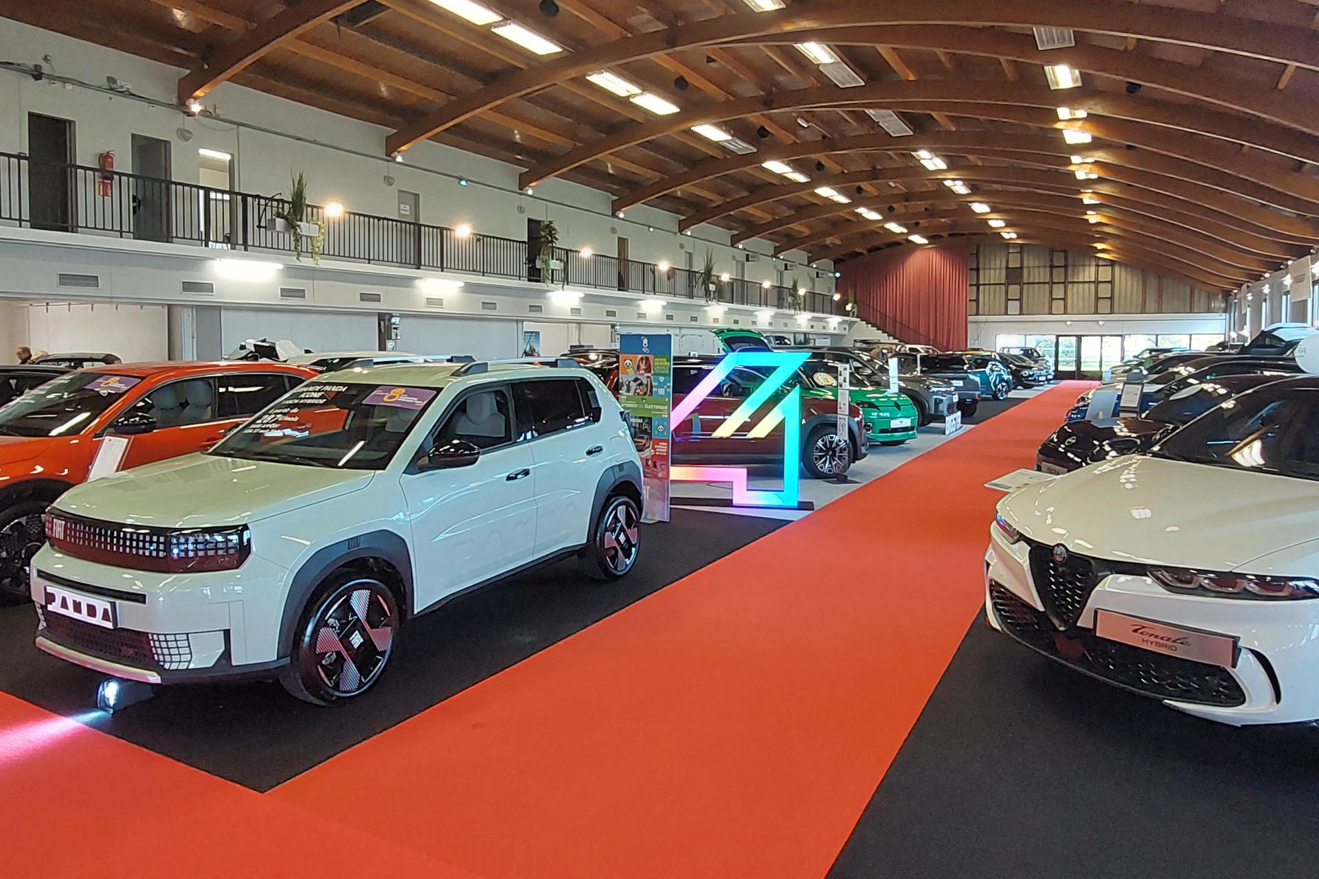 De part et d'autre d'un long couloir, des rangées de véhicules se succèdent au Palais du Lac de Vichy .