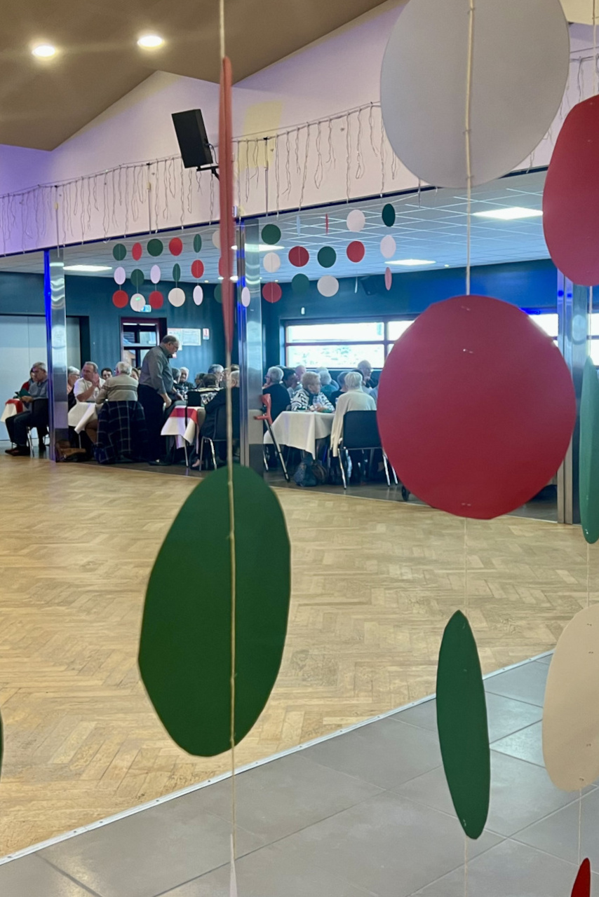 Les aînés se préparent pour le repas, au thème de l'Italie, dans un contexte de jumelage avec la ville de Mazzano.