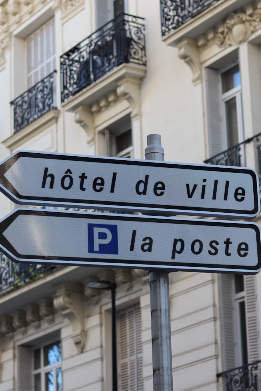 Ce panneau indique la direction vers l’Hôtel de ville (à gauche) et la place de la Poste (à droite).