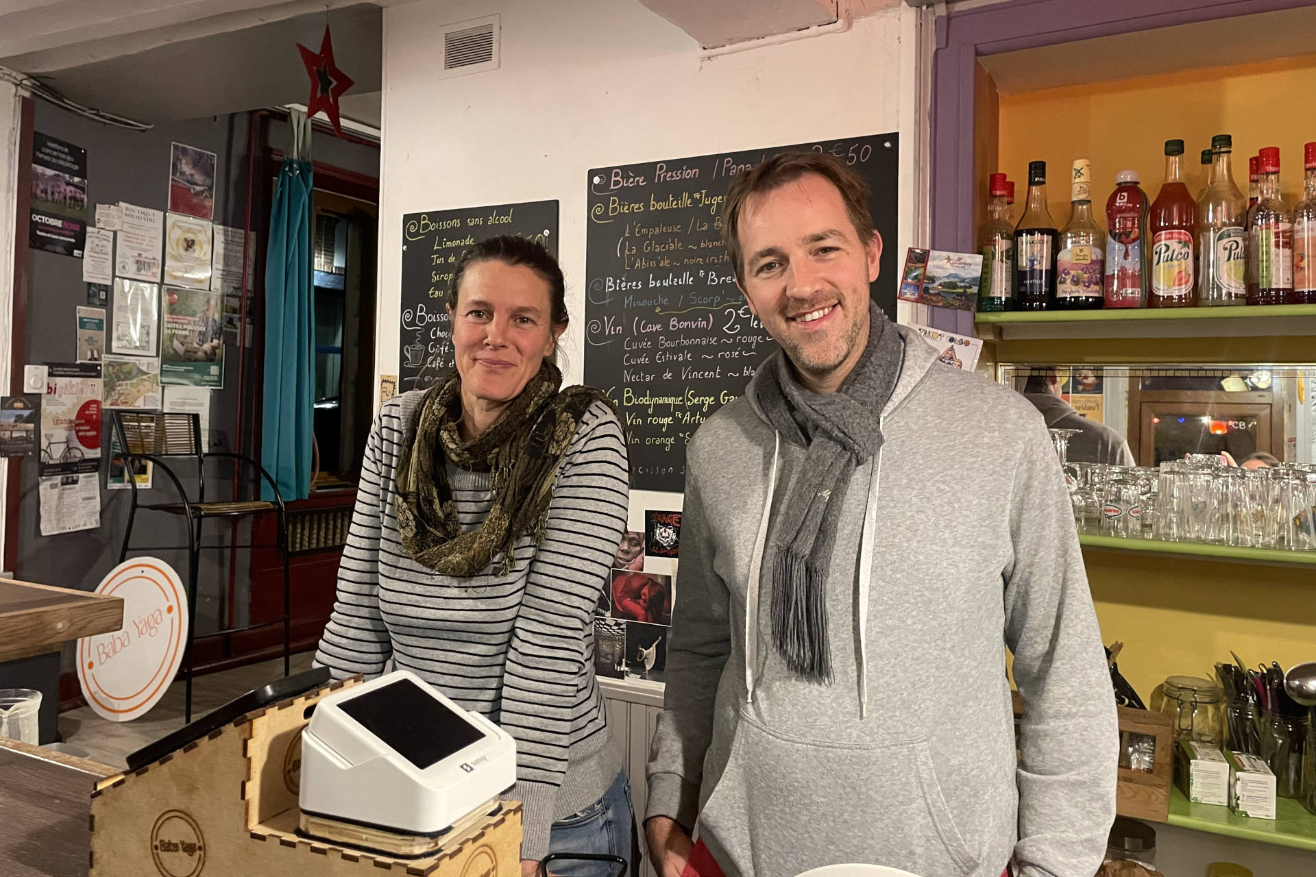 Deux bénévoles se tiennent debout derrière le bar au Baba Yaga.