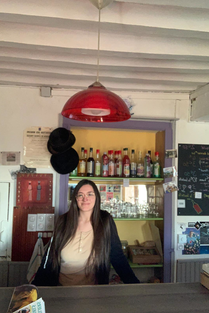 Clotilde, jeune salariée, sourit derrière le bar