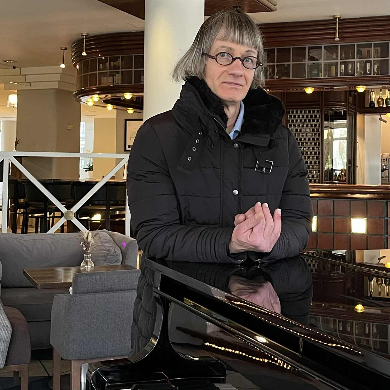 Avec sa coupe au carré et ses petites lunettes rondes, Saint-Philippe pose sur un piano à l’hôtel Vichy Célestins.