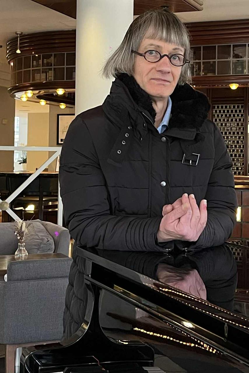 Avec sa coupe au carré et ses petites lunettes rondes, Saint-Philippe pose sur un piano à l’hôtel Vichy Célestins.